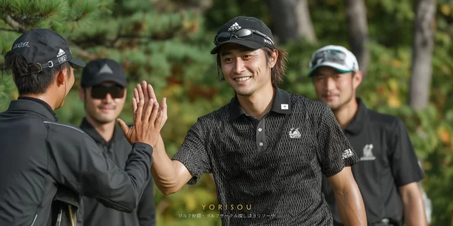 春日井市西本町エリアから参加した男性ゴルファーが、ゴルフウェア姿でバストアップ、仲間とハイタッチを交わしながらラウンドを楽しんでいる様子