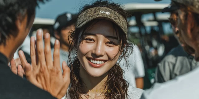 徳島市沖浜町のゴルフ場で、ゴルフウェア姿の30代女性ゴルファーが仲間とハイタッチを交わし、自然な笑顔を見せているバストアップ写真