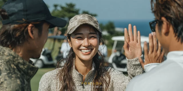 八幡平市平舘エリアのゴルフ場で、プレー後に仲間とハイタッチする30代女性ゴルファーが、ゴルフウェア姿で明るく笑顔を見せているバストアップ写真