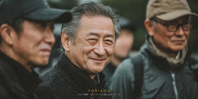 宮崎市大塚町周辺のゴルフ場で、ゴルフウェア姿の60代男性がバストアップで穏やかに微笑み、仲間と談笑している場面