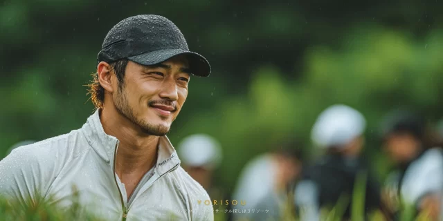 愛知県豊田市御作町方面のゴルフ場で、ゴルフウェア姿の男性ゴルファーがバストアップで写り、雨天の中でも落ち着いた表情でラウンドを楽しんでいる様子