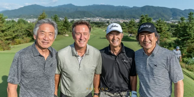 海南市名高エリアのゴルフコースで、60〜70代の男性ゴルファー4人がゴルフウェア姿で肩を並べ、穏やかな表情でバストアップ撮影している様子