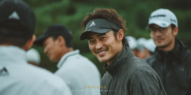 春日市エリアのゴルフ場で、40代男性ゴルファーが仲間と談笑しながら振り返り、穏やかな笑顔を見せるバストアップ写真