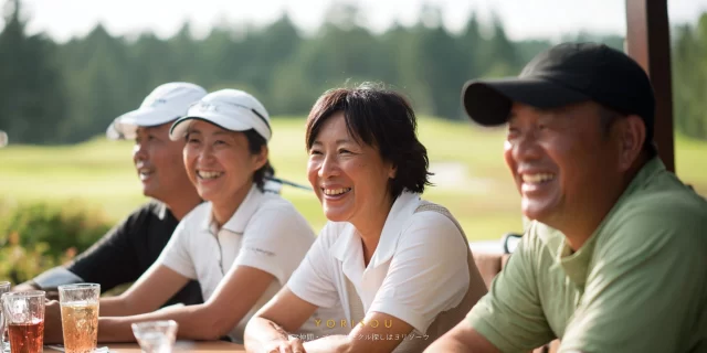 市原市内のゴルフ場レストランで、ラウンド後に食事を楽しむ40〜60代のゴルフ仲間の自然な会話風景