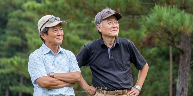 市原市姉崎エリアで、60代のゴルフ仲間がラウンド中に落ち着いて会話している雰囲気
