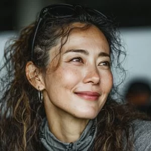 高知市在住の50代女性ゴルファーが、ゴルフウェア姿で平日のゴルフ場に立ち、バストアップで落ち着いた笑顔を見せている様子