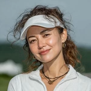 北広島市在住の50代女性ゴルファーが、ゴルフウェア姿でバストアップの笑顔を見せている様子